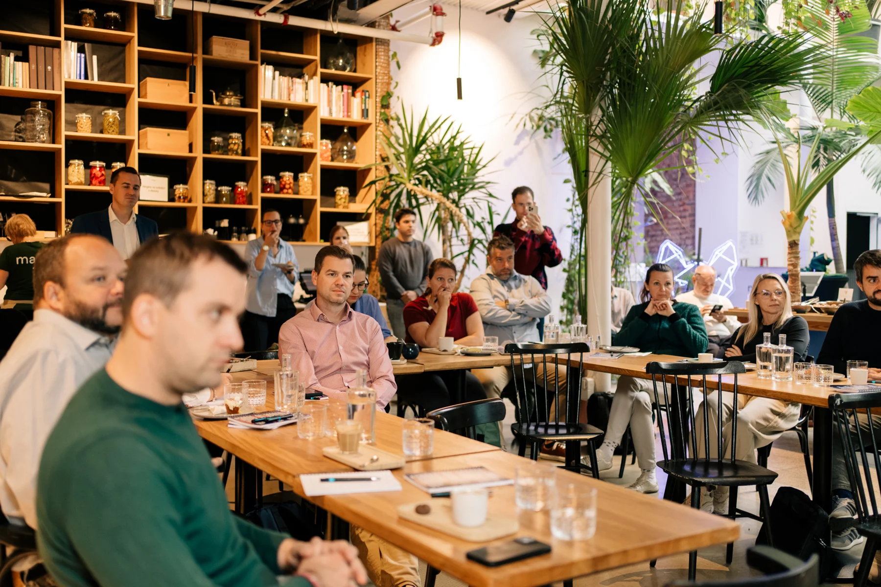 Účastníci Dingo Breakfast sledují prezentaci u společného stolu
